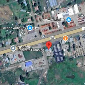 A satellite map view showing businesses along Highway 160, including Longshot Concrete Pumping, Southwest Ag Inc, and Village Junction Antiques.
